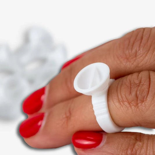 Cups anillos desechables for micropigmentation in use on a finger.